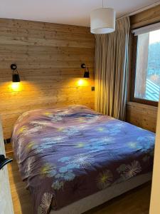 ein Schlafzimmer mit einem Bett und einer Holzwand in der Unterkunft Résidence Albane, T3 entièrement refait in Vars + 24 Fotos