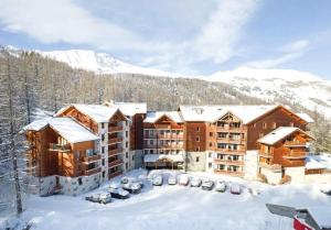 ein großes Wohnhaus mit Schnee auf dem Boden in der Unterkunft Résidence Albane, T3 entièrement refait in Vars
