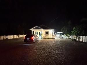 a car parked in front of a small house at night at Omah Kebun Private Pool in Sungai Besar
