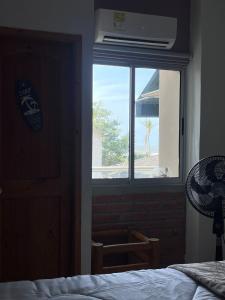 a bedroom with a window with a view of the ocean at Mar, Hamaca, BBQ y Cocina, Hogar Entre Olas in Puerto Colombia