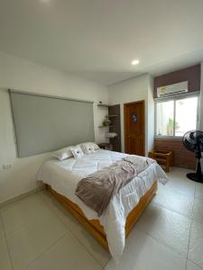 a bedroom with a large bed with a large screen on the wall at Mar, Hamaca, BBQ y Cocina, Hogar Entre Olas in Puerto Colombia