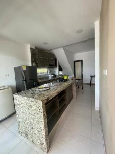 a kitchen with a granite counter top in a room at Mar, Hamaca, BBQ y Cocina, Hogar Entre Olas in Puerto Colombia