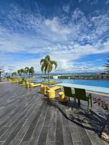 a row of benches next to a swimming pool at Mactan Cozy Studio in Lapu Lapu City