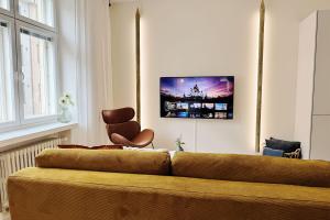 a living room with a couch and a chair at Luxury 3-Bedroom Suite on Most Beautiful Street of Helsinki in Helsinki