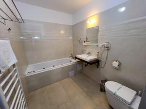 a bathroom with a tub and a sink and a toilet at Hotel Arman in Nižná +36 photos