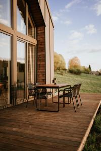 eine Holzterrasse mit einem Tisch und Stühlen darauf in der Unterkunft Kamienna Azyl - domek z sauną i balią, Kotlina Kłodzka in Kamienna