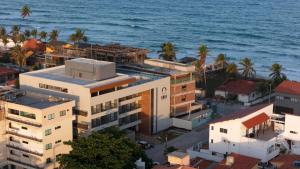 an aerial view of a building next to the ocean at Ora Beach 108 Porto de Galinhas in Porto De Galinhas
