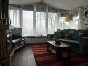 a living room with a couch and a table at Bay 1 in Kirkcolm