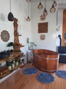een kamer met een houten badkuip en twee blauwe tapijten bij La Luciolla Loft Cabana in São Marcos