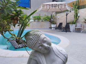 een standbeeld van een hoofd naast een zwembad bij La Luciolla Loft Cabana in São Marcos