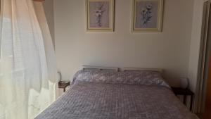 a bed in a bedroom with two pictures on the wall at Carballo de Cereixo - Solo con seña in Federación