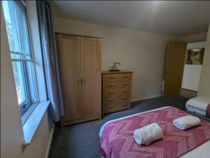 a bedroom with a bed and a dresser and a window at Newcastle Riverside Executive Apartment in Newcastle upon Tyne +3 photos