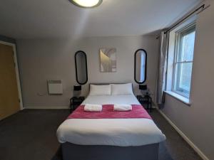 a bedroom with a large bed with two towels on it at Newcastle Riverside Executive Apartment in Newcastle upon Tyne