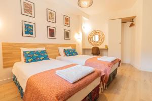 a bedroom with two beds and a mirror on the wall at AfroBoHome, Expérience Atypique, clim, 2 à 6 personnes, Proche centre Nîmes, Garage clos in Nîmes