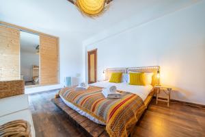 a bedroom with a large bed with yellow pillows at Casa do Sol in Bordeira