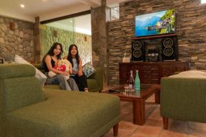 two women sitting in a living room holding a teddy bear at Casa linda de Chontay junto al rio in Chontay