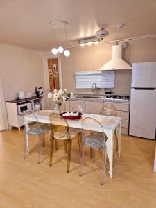 a kitchen with a table and chairs and a white refrigerator at Stay Savage in Seoul