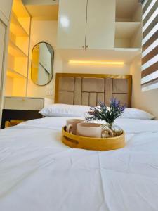a tray with bowls and flowers on a bed at RJ Elite Escape 2BR Condo w balcony near SM Iloilo in Iloilo City +19 photos