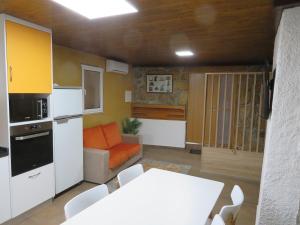 a kitchen and living room with a table and a couch at Casa do Cortinhal in Covilhã +3 photos