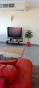 a living room with a red couch and a flat screen tv at Nabq paradise in Sharm El Sheikh