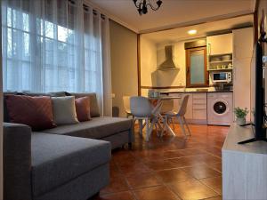 a living room with a couch and a table at Apartamentos El Ardinal in Arenas de Cabrales