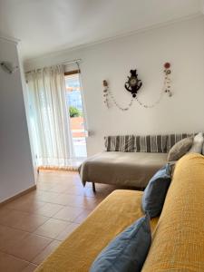 Una sala de estar con dos camas y una ventana. en Sesimbra Village T1, en Sesimbra