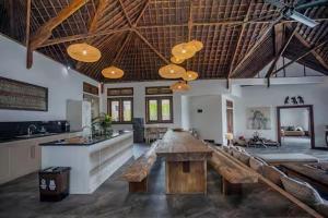 a large living room with a table and a bar at Villa Senja in Nusa Lembongan