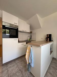 a kitchen with white cabinets and a counter top at Ferienwohnung im Haus am See in Hohennauen