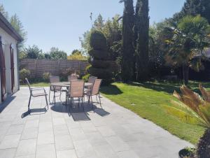 a patio with a table and chairs in a yard at Villa évasion in Ambillou