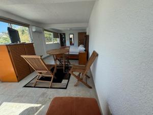 a room with chairs and a table and a bedroom at VILLA COSTERA HOTEL BOUTIQUE in Acapulco