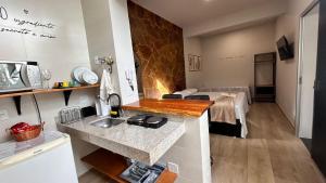 a kitchen with a sink and a room with a table at Aconchego BH in Belo Horizonte +11 photos