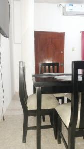 a black dining room table with chairs and a piano at Apartamento vacacional in Manta