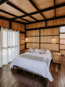 a bedroom with a bed in a room with wooden walls at Copoazú Glamping in Floridablanca +79 photos