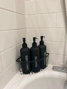 three black bottles sitting on top of a bathroom sink at Manchester Central - Modern Apartment - Free Parking in Manchester