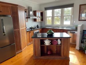 a kitchen with a island in the middle of it at That White House in Warrnambool