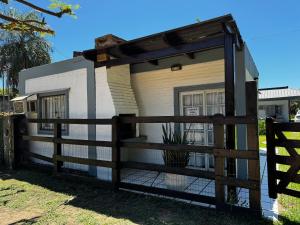 ein Haus mit einem Zaun davor in der Unterkunft Excelente Casita en Paso in Paso de la Patria