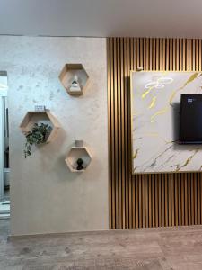 a wall with a painting on a wall with two shelves at Sunset LOFT Mangalia in Mangalia