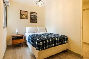 a bedroom with a bed with a plaid blanket at Confortable apartamento en Miraflores cerca del malecón C1 in Lima +12 photos