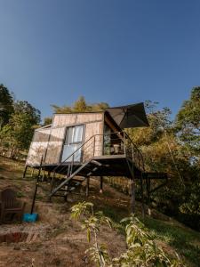 a tiny house on a stand in a field at Copoazú Glamping in Floridablanca