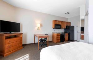 ein Zimmer mit einem Bett und einem Schreibtisch mit einem Fernseher in der Unterkunft Extended Stay America Suites - San Antonio - North in San Antonio