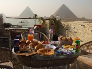 stół z jedzeniem śniadaniowym i piramidami w obiekcie Solar Boat Pyramids View Hotel w Kairze