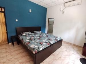 a bedroom with a bed in a blue room at Corner Cottage Anuradhapura - Homestay and Cooking Class in Anuradhapura