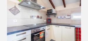 a kitchen with white cabinets and a stove at Villa Caraibe in Petit-Canal +19 photos