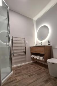 a bathroom with a shower and a toilet and a sink at Hillcrest Hideaway in Rotorua