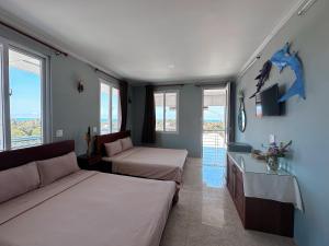 a room with two beds and a couch and windows at SnS Muine Homestay in Mui Ne +48 photos