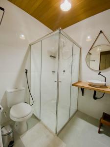 a bathroom with a toilet and a glass shower at Kwati Villa in Parintins