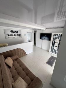 a living room with a couch and a tv at Hotel Valle del Café - Habitación 2 Familiar con 2 camas in Sevilla