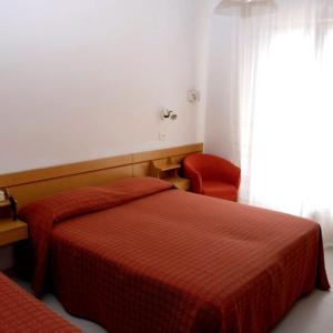 リッチョーネにあるHotel San Remoのベッドルーム1室(赤いベッド1台、赤い椅子付)