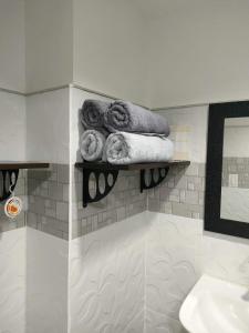 a bathroom with a shelf with towels and a sink at Cebu Stay Rental - Sunvida Tower Residences in Cebu City