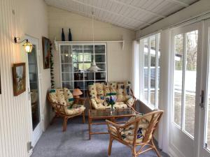 a screened in porch with chairs and a table at 6 person holiday home in Ansager in Ansager +29 photos